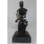 A sculpture of a contemplative skeleton on a black marble plinth base