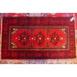 A north east Persian Turkoman rug, 200cm x 113cm, with a triple pole medallion on a rouge field