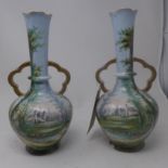 A pair of late 19th century Continental twin handled vases, decorated with landscape scenes, H.