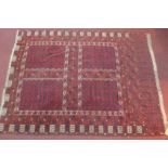 An antique Afghan rug, the stylised ivory rectangular medallion on a terracotta ground within