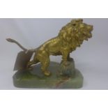 A gilt spelter sculpture of a lion on an onyx base
