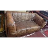 A 1970s tan leather two seater sofa, in the manner of Desede, along with a matching armchair (2)
