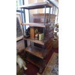 An industrial display unit/bookcase, with five solid teak planks having iron rod supports, raised on