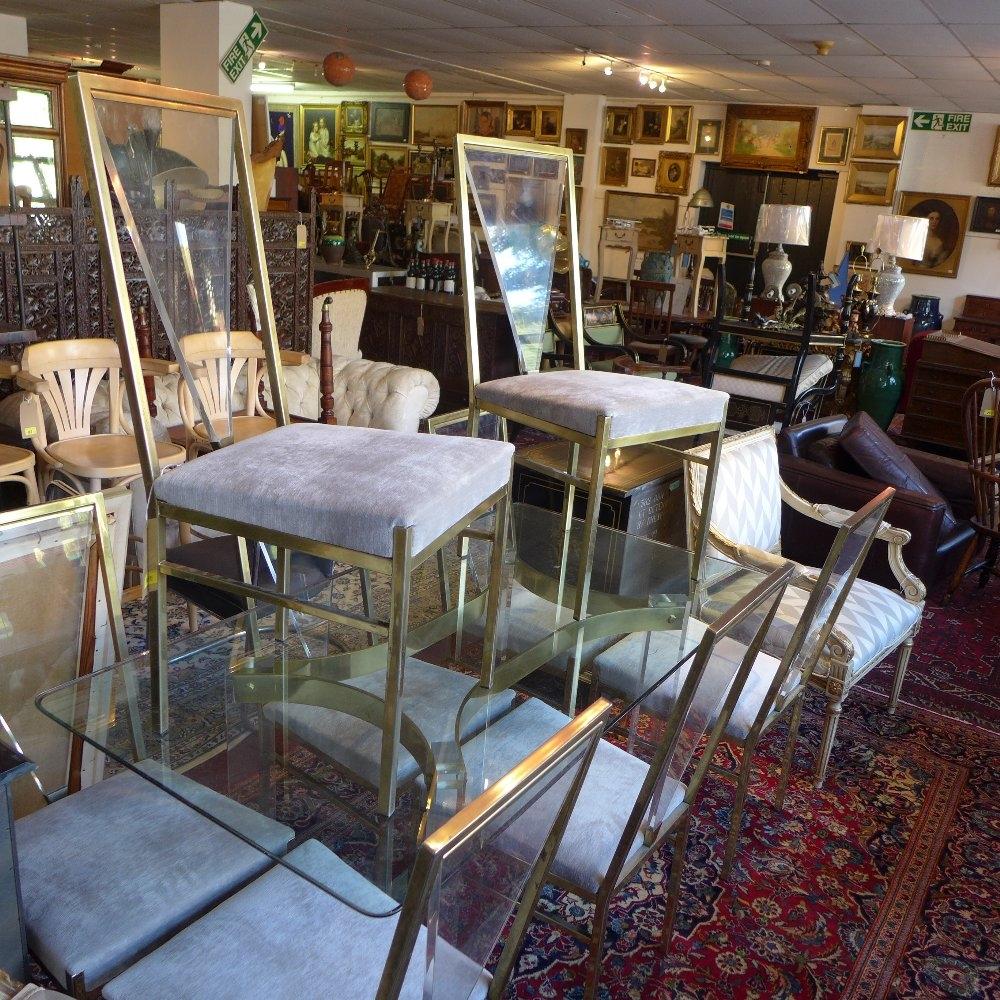 A 1970's Roche Bobois gilt metal and perspex dining table with glass top, together with eight