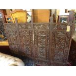 A 20th century Indonesian carved hardwood four fold screen, with leaf and berries decoration,