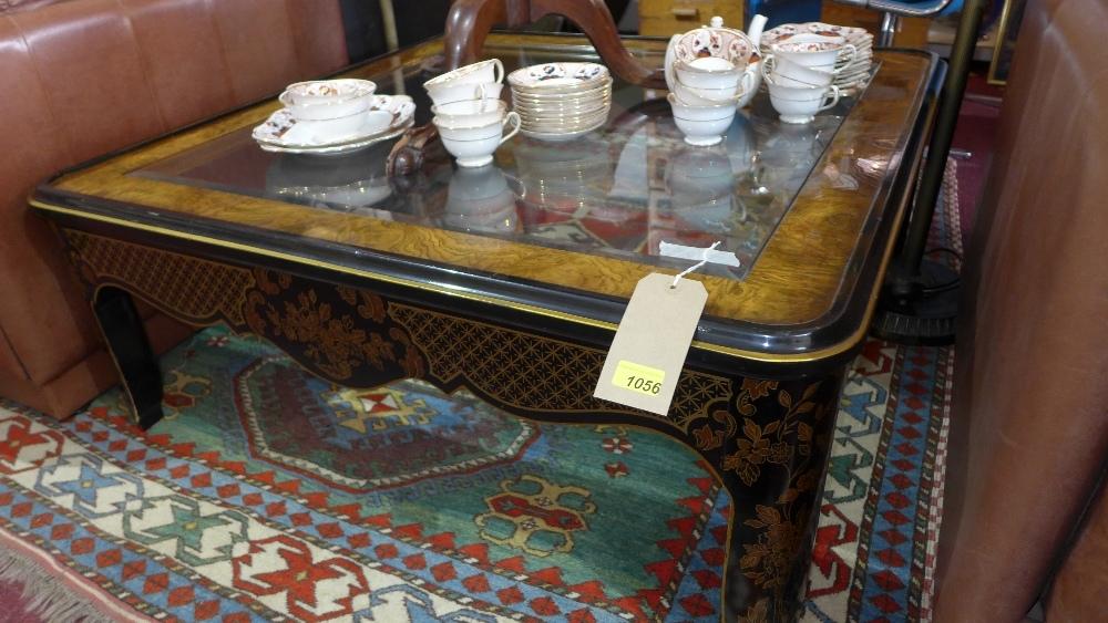 A large Drexel Heritage burr walnut and black lacquered square coffee table, with gilt floral