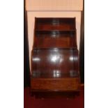 An early 19th Century mahogany waterfall fronted set of of wall hanging shelves with single lower