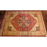 A Heriz style carpet, the central medallion on a ruby ground within a wide stylised ivory border,