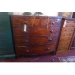 A Georgian mahogany bow front chest of two short over three long drawers, with turned rosewood