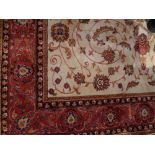 A Keshan style rug, the palmette and vine design on a beige ground within a rouge border, L.230cm