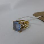 A yellow metal and aquamarine ring (probably gold), cushion cut inset aquamarine