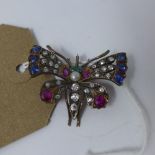 A Continental Austrian yellow metal brooch in the form of a butterfly inset with rubies, sapphires