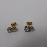 A pair of ladies yellow metal and diamond stud earrings, each have two round cut diamonds