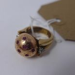 A ladies yellow metal dress ring in globe form, inset with rubies and diamonds (probably gold)