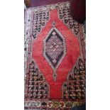 A North West Persian Mazlaghan rug, central diamond medallion on a rouge field within stylised ivory