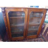 An Aesthetic Victorian mahogany bookcase, with two glazed doors enclosing adjustable shelves, raised