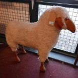 A large vintage model of a stuffed sheep with wooden legs and face, H.87 W.84 D.24cm