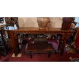 An early 20th century Chinese hardwood altar table, raised on pierced and carved pillar supports,