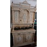 A 19th century white painted oak dresser, with three carved doors above two drawers and two