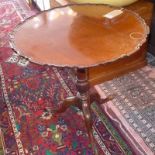 A Georgian mahogany tilt top table, with pie crust top, raised on splayed legs having paw feet