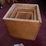 A nest of three wooden box tables, with twin handles and visible dovetail joints, Largest H.30cm W.