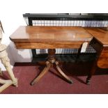 A 19th century mahogany fold over tea table, raised on turned support, four splayed legs and castors