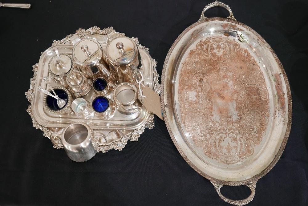 A collection of silver-plated items to include trays, a salver, salt cellars with blue glass linings