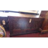 A mid 17th century oak coffer, with three deeply carved floral panels, having marquetry inlay, above