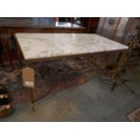 A 1950s French low table, with a variegated white marble top on reeded brass stretchered supports,