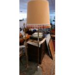 A set of two mid century brass standard lamps, one with an oversized tassle fringed shade, H.