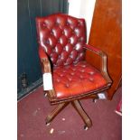 A Gainsborough style swivel desk chair, upholstered in deep buttoned red faux leather, H.91cm