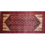 A North East Persian Meshad belouche rug, 210cm X 110cm. Repeating stylised geometrical motifs on