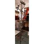 A Continental wrought metal standard lamp with six intertwining branches raised on a star base, H.