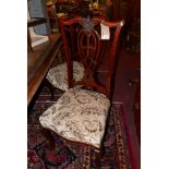 A set of four late 19th Century mahogany dining chairs, with carved splat backs and floral