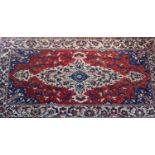 A North West Persian Bakhara carpet, 285cm X 154cm. Central ivory floral medallion on a rouge