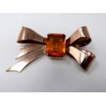 A silver and rose gold plated bow brooch set with an orange citrine