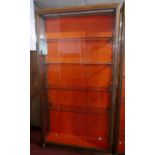 An early 20th Century walnut and bronze display case with fitted glass shelves and red baize