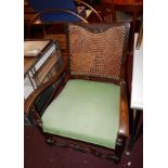 A pair of Edwardian oak armchairs with cane back rests