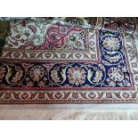 A Kashan style carpet, with central floral medallion on a beige ground, contained by floral borders,