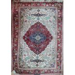 A signed Persian part silk rug, the ruby pendant medallion on an ivory ground with palmettes and