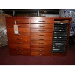 A teak haberdashery cabinet, with 18 drawers beside 14 plastic trays, H.57 W.88 D.37cm