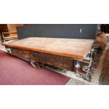 An industrial style low table, with an oak plank top raised on wheels, H.33cm D.66cm L.139cm
