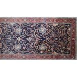 A North West Persian Sarouk runner, repeating stylised spandrels on a sapphire field within floral