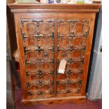 An Indonesian teak side cabinet, with carved panel cupboard doors, H.100cm W.70cm D.35cm