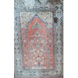 A 19th Century Persian silk rug, the central tree of life design on a salmon pink ground within a