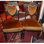 A set of four early 20th century Art Nouveau carved oak dining chairs, with golden velour upholstery