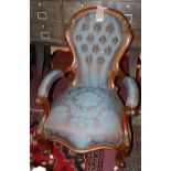 A 19th century carved mahogany armchair upholstered with silk damask and with button-back detailing,