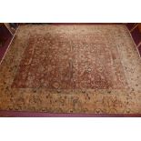 A large Indian hand knotted rug, with an all over palmette and vine decoration on a burgundy ground,