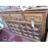An Indonesian teak side cabinet, with three short drawers over carved panel cupboard doors, H.90cm