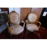 A pair of Louis XV style giltwood armchairs with floral upholstery, raised on reeded tapered legs